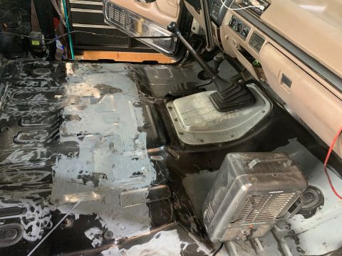 1996 Ford Bronco - The interior of a vehicle shows exposed floor pans and a manual transmission, suggesting a restoration project is in progress.