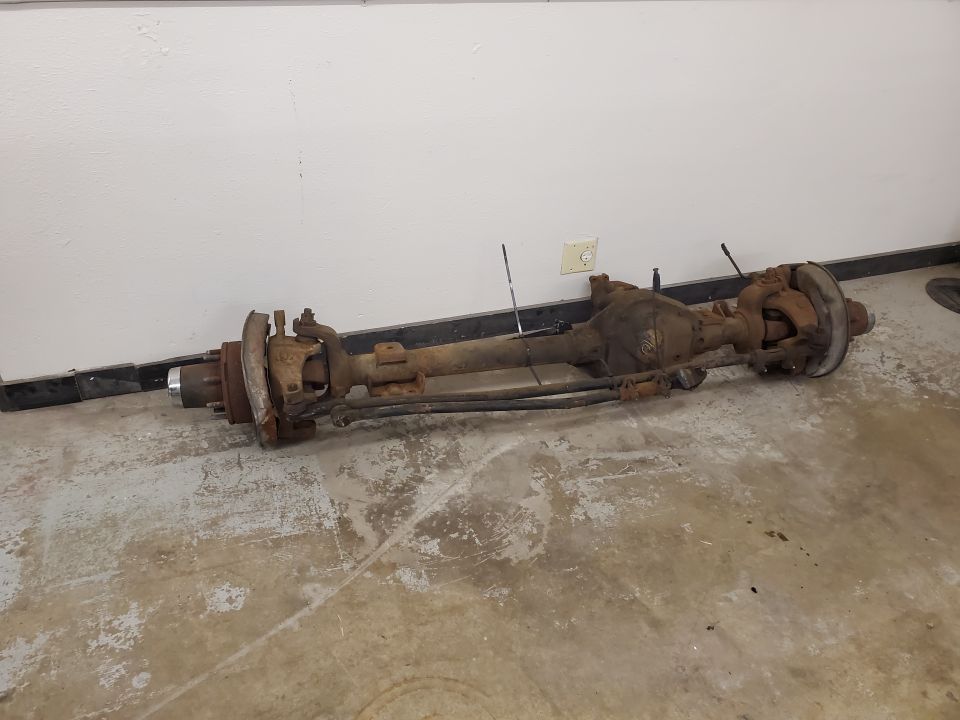 Rusty vehicle axle assembly with brake components and steering linkage