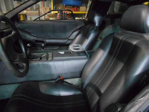1992 Ford Bronco - The interior of a car is shown, black leather seats and a view of the dashboard and center console.