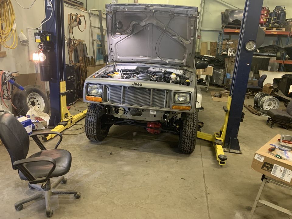 Silver 2000 Jeep Cherokee front view in garage, hood open