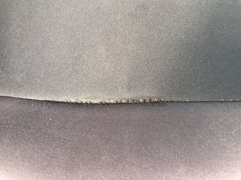 2000 Ford Explorer - Close-up of a worn black fabric seam splitting along the stitching between two upholstery panels in a vehicle interior.