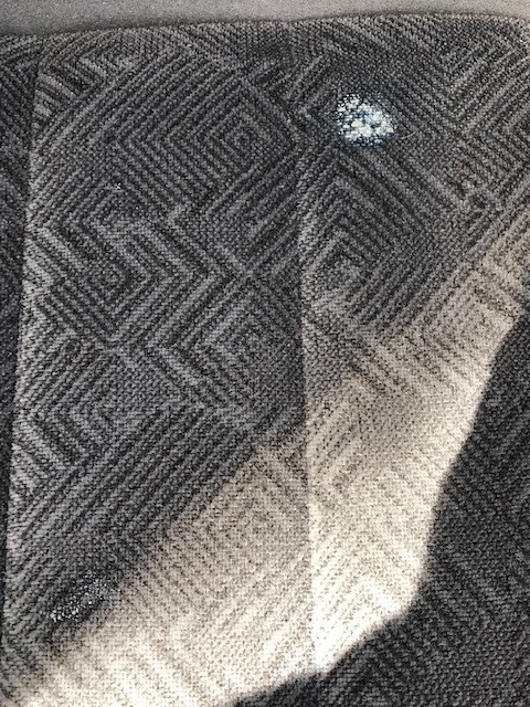 2000 Ford Explorer - The patterned upholstery of a vehicle's interior shows some wear and a small stain.