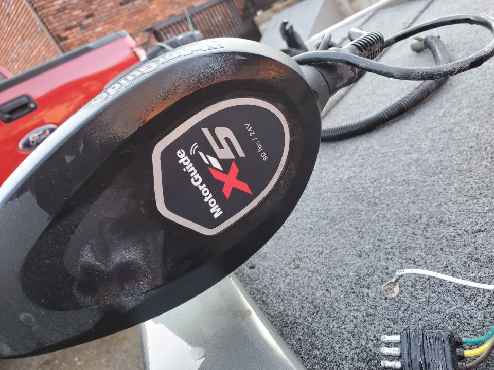 MotorGuide trolling motor on a boat, with a red Ford truck in the background
