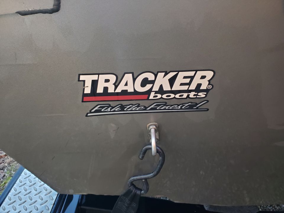 Gray boat stern with "TRACKER boats Fish the Finest!" decal and a metal hook with strap