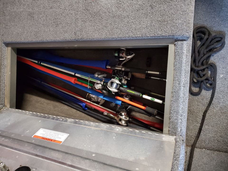 Fishing rods with colorful sleeves stored in a boat compartment