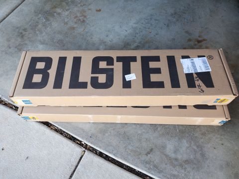 1996 Ford Bronco - Two boxes with the Bilstein logo are stacked on a concrete surface, likely containing vehicle parts.