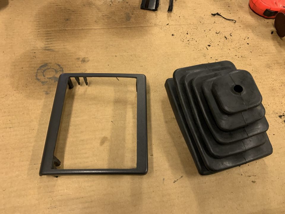 Jeep Cherokee shift boot and dash trim piece on a workbench