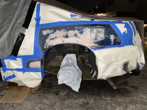 2000 Pontiac Grand Prix - Car body panel being prepped for paint with masking tape and paper covering surrounding areas.