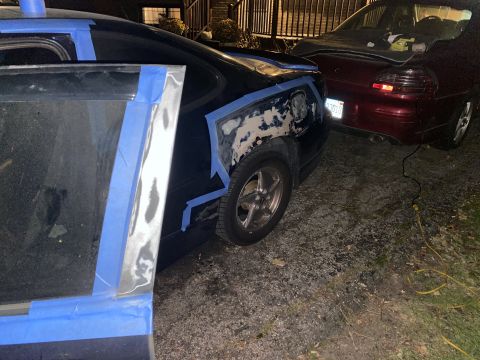 2000 Pontiac Grand Prix - A car is being prepped for body work, with blue tape outlining the repair area.