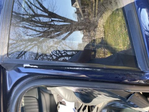 2000 Pontiac Grand Prix - The interior of a car is visible, with reflections of trees and a building in the window.