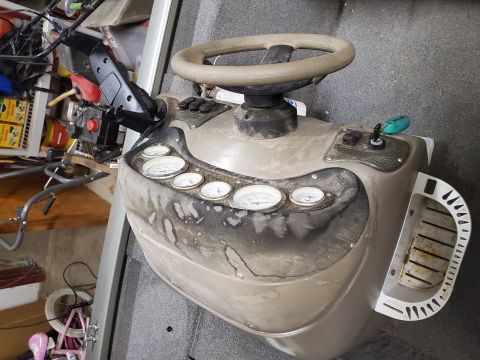 2005 Tracker Tournament - The interior of a boat shows a weathered console with a steering wheel and several gauges.