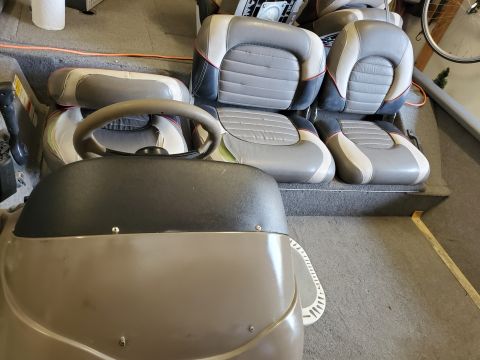 2005 Tracker Tournament - Interior view of a boat, showing multiple rows of upholstered seats and the steering console.