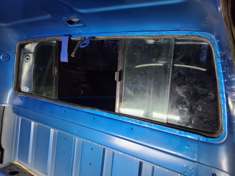 1995 Ford F-150 - The split rear window of a 1995 Ford F-150 is visible from the interior of the cab.