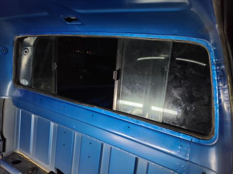 1995 Ford F-150 - Blue truck cab interior with a view of the rear window and side paneling.