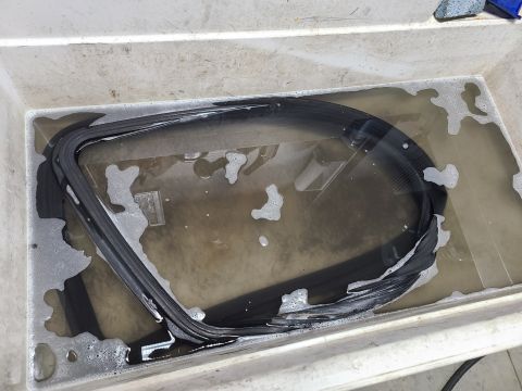 1995 Ford F-150 - A rubber seal is submerged in a tub of soapy water, likely for cleaning or preparation.