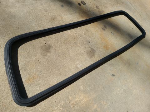 1995 Ford F-150 - A rubber seal for a split rear window is shown on a concrete surface.