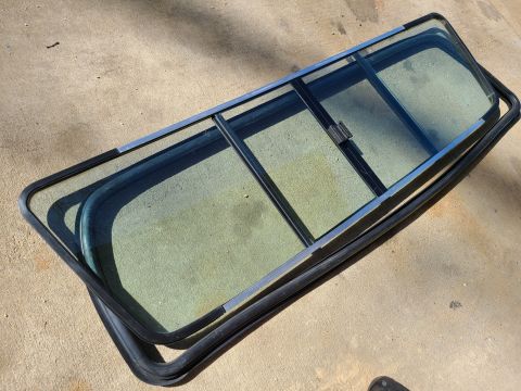 1995 Ford F-150 - A disassembled split rear window assembly lies on a concrete surface.