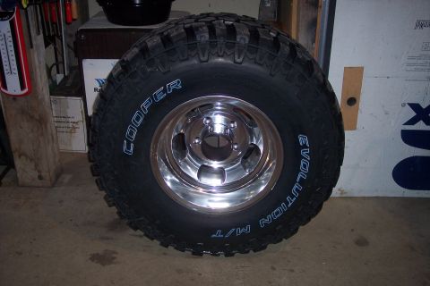 1978 Ford Bronco - A close-up of a Cooper Evolution M/T tire mounted on a shiny chrome wheel.