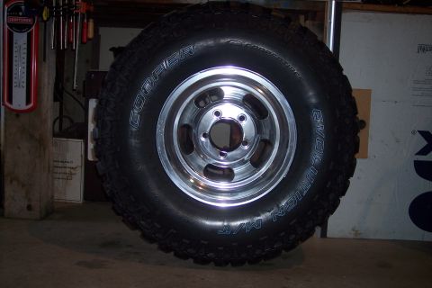 1978 Ford Bronco - A close-up of a Cooper Evolution M/T tire mounted on a chrome wheel.