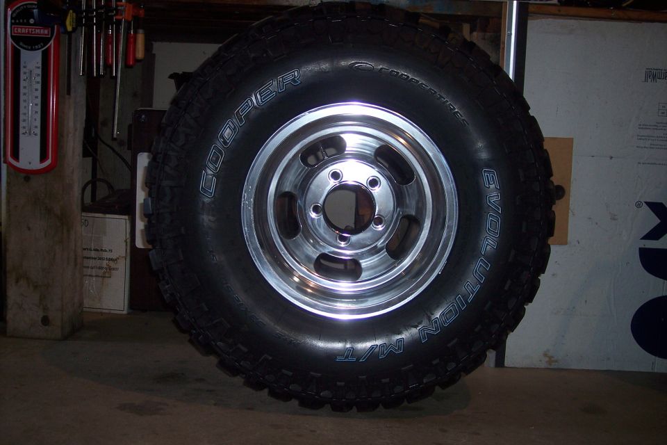 Tire with Cooper Evolution M/T branding on a chrome five-spoke wheel