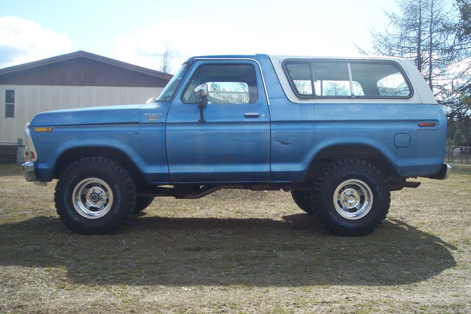 Side view of blue 1978 Ford Bronco with white top and off-road tires