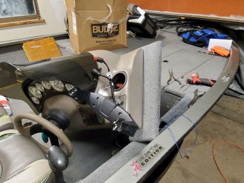 2005 Tracker Tournament - The interior of a boat shows a steering console with gauges and various tools laid out on the deck.