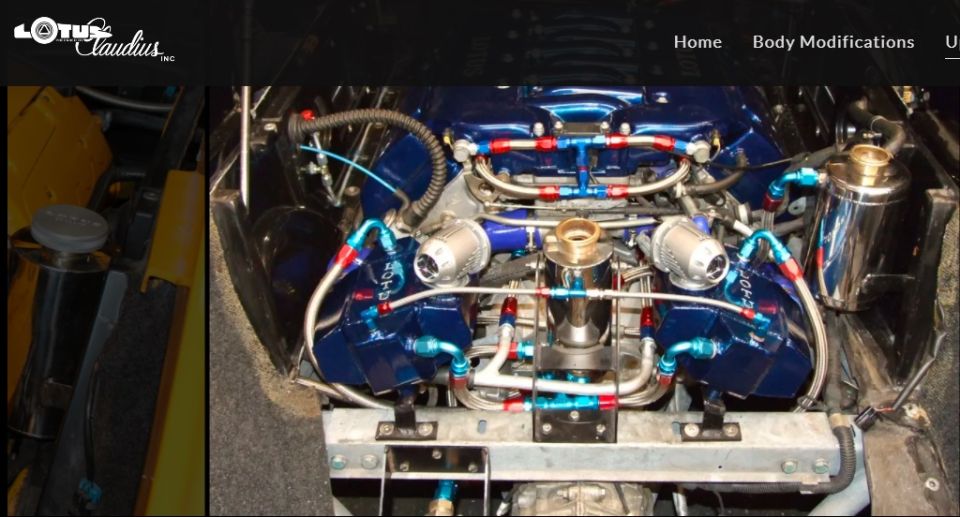 Lotus V8 engine with blue painted intake manifolds and custom red and blue braided fuel lines