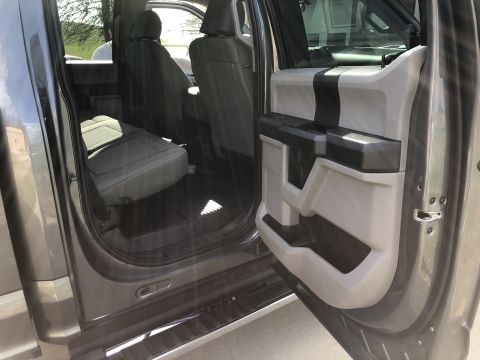 2021 Ford F-250 - The interior of a truck is visible with the rear doors open, revealing the back seats and door panels.