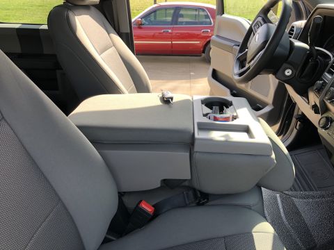 2021 Ford F-250 - The photo shows the interior of a truck, including the center console and seats, with a red car visible through the window.