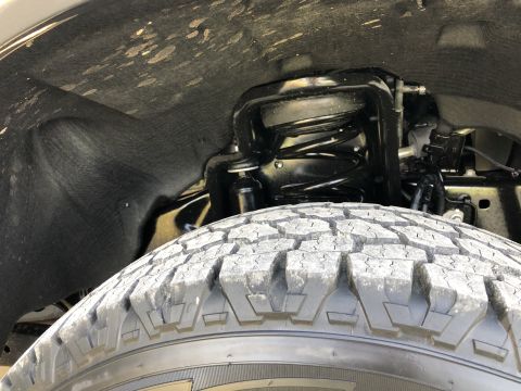 2021 Ford F-250 - Close-up view of the front wheel well and suspension system of a truck, with a watermark from Supermotors.net visible.