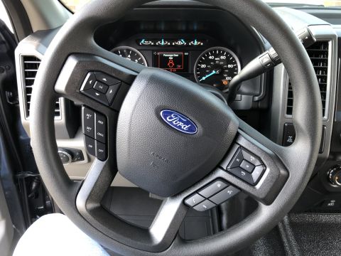 2021 Ford F-250 - The interior of a 2021 Ford F-250 features a Ford-branded steering wheel and a digital display on the dashboard.