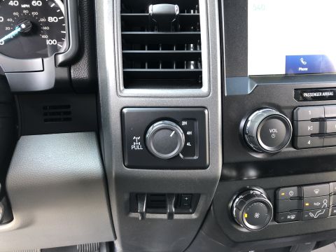 2021 Ford F-250 - The interior of a truck shows the 4x4 selector, volume control, and climate settings.