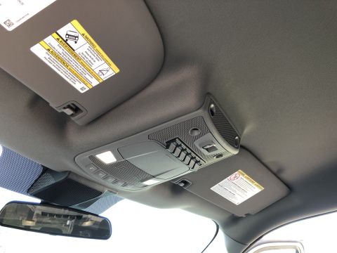 2021 Ford F-250 - The overhead console of a vehicle, interior lights and control buttons, with sun visors visible.
