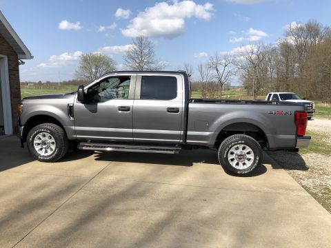 2021 Ford F-250 - Side view of a gray 2021 Ford F-250 Super Duty pickup truck parked outside a garage.