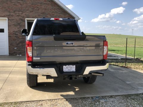 2021 Ford F-250 - 2021 Ford F-250 Super Duty pickup truck's rear end is shown parked outside a brick house.