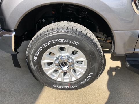 2021 Ford F-250 - Close-up of a gray pickup truck's front wheel and fender, showing tire details and chrome accents.