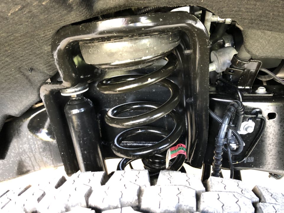 Front suspension coil spring and shock absorber assembly, part of a truck's undercarriage