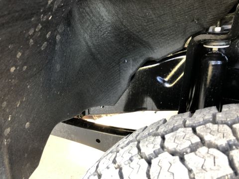 2021 Ford F-250 - This image shows the inner fender liner and suspension of a vehicle, with a tire in the foreground.
