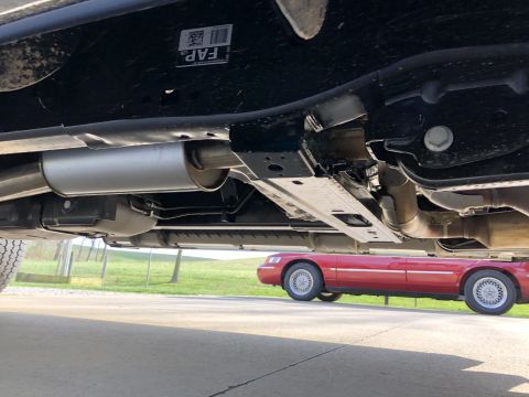 2021 Ford F-250 - The underside of a truck is shown, with a red sedan visible in the background. No year-specific details are apparent on the truck.