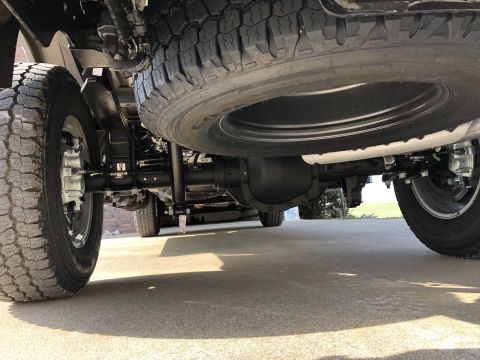 2021 Ford F-250 - Close-up view of the undercarriage of a truck, showing the spare tire, suspension components, and rear axle.