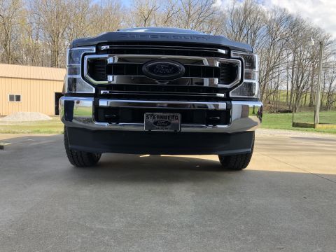 2021 Ford F-250 - This 2021 Ford F-250 Super Duty features a prominent black grille with chrome accents and the iconic Ford emblem.