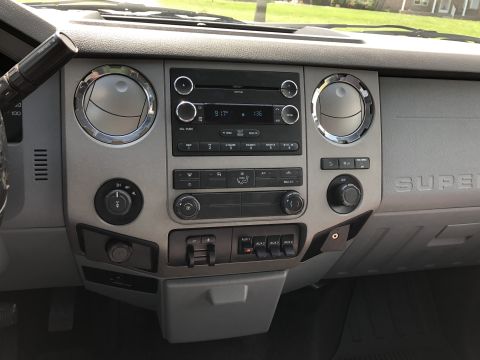 2011 Ford F-250 - The interior of a 2011 Ford F-250 features a gray dashboard with a central infotainment system and climate controls.