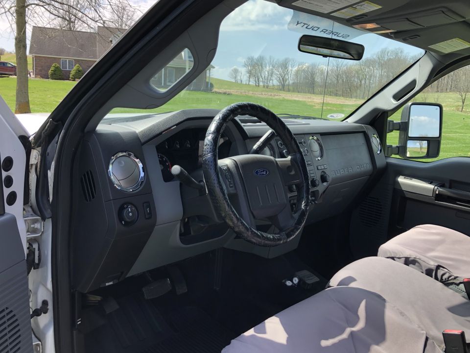 Interior of a 2011 Ford F-250 Super Duty truck, showing the dashboard, steering wheel, and seats