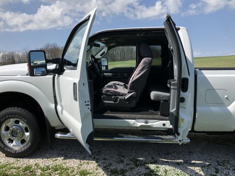 2011 Ford F-250 - Interior view of a 2011 Ford F-250 pickup truck with both front doors open.