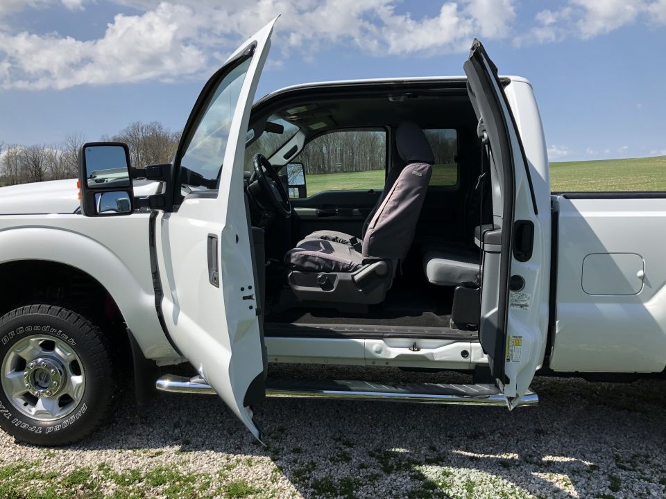 2011 Ford F-250 interior with front doors open, showing seats and dashboard