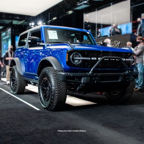 2021 Ford Bronco - A blue 2021 Ford Bronco is displayed with its distinctive grille and off-road tires.