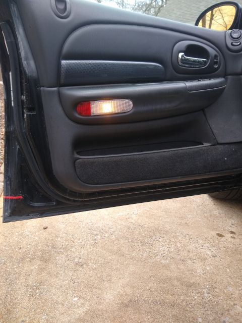 2002 Chrysler 300M - Interior door panel with illuminated courtesy light and textured armrest.