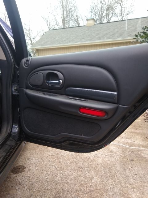 2002 Chrysler 300M - Interior view of a car door, showing the handle, speaker grille, and a red reflector.