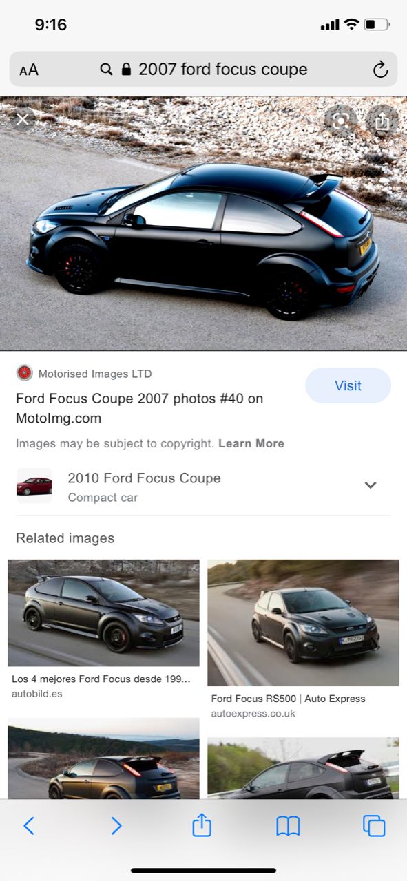 Black Ford Focus coupe parked on a dirt road