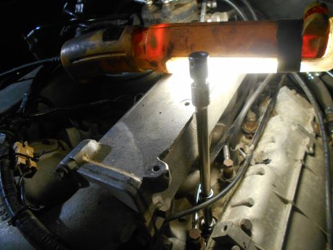 1992 Ford Bronco - Engine components are visible under a work light, with a socket extension in place.